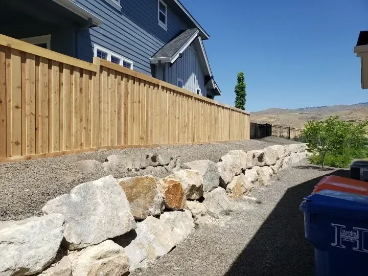 Board on board cedar fence built above a rock retaining wall in Boise