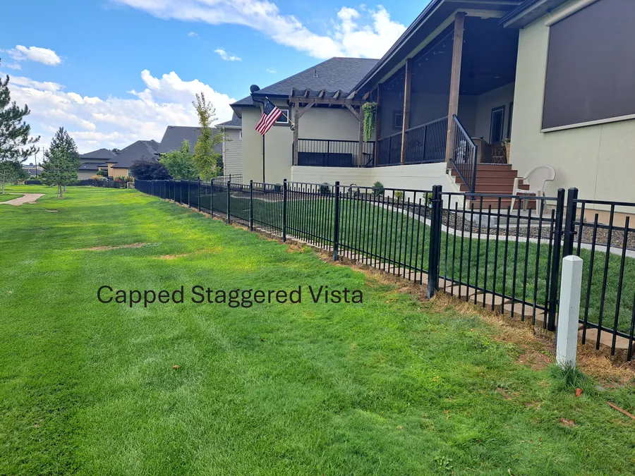 Capped staggered vista wrought iron fence along a green lawn at a Boise home