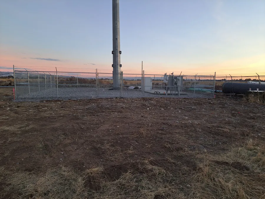 Chain link perimeter fence around a commercial site at dusk in Idaho
