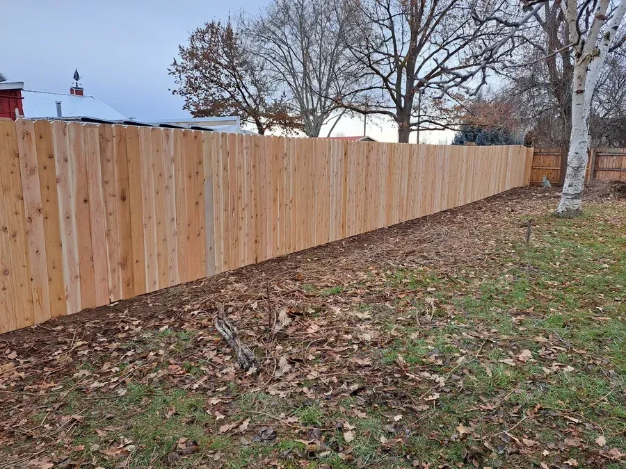 Dog eared cedar fence along a property line in the Treasure Valley in late autumn