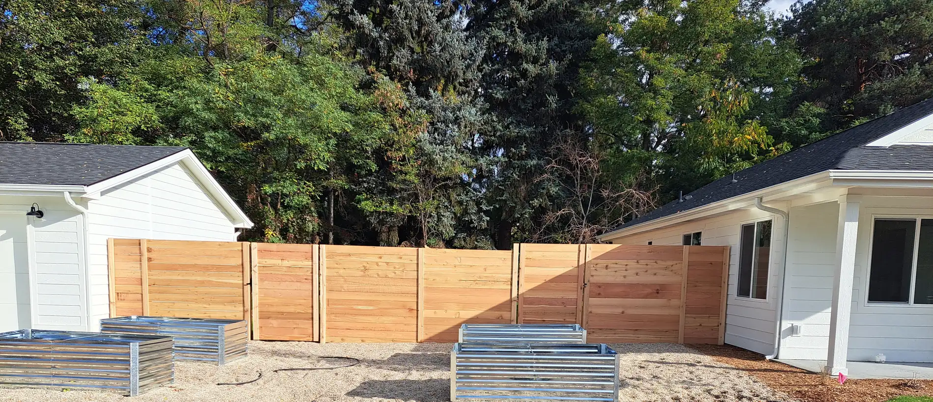 Horizontal cedar fence panels enclosing a Boise backyard with raised garden beds