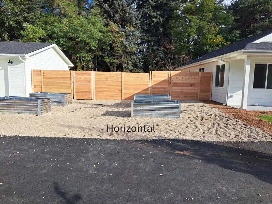 Horizontal cedar fence panels enclosing a Boise backyard with raised garden beds