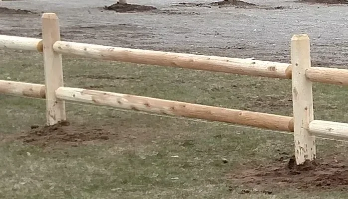 Peeled pole ranch fence set into a graded lot in rural Idaho