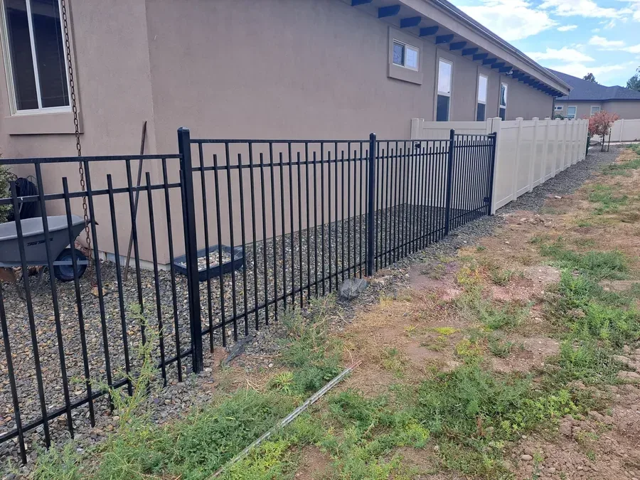 Staggered vista capped wrought iron fence running along a commercial building in Boise