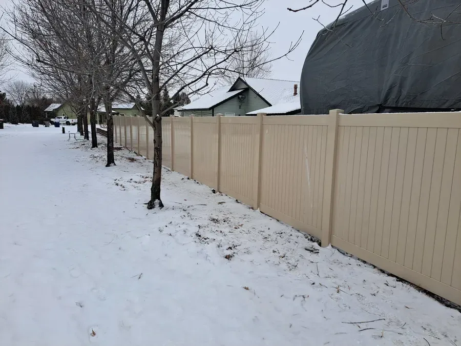 Tan vinyl privacy fence holding up through an Idaho winter in Nampa