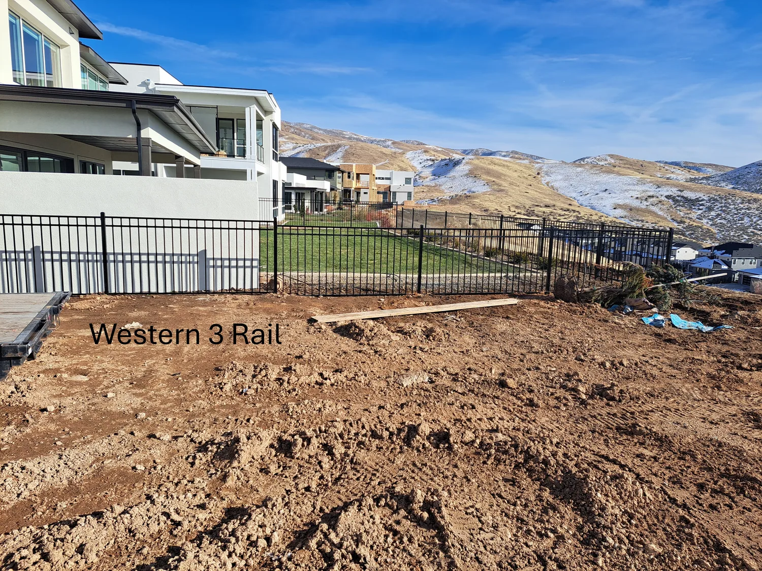Western three rail wrought iron fence at a new construction home below the Boise foothills