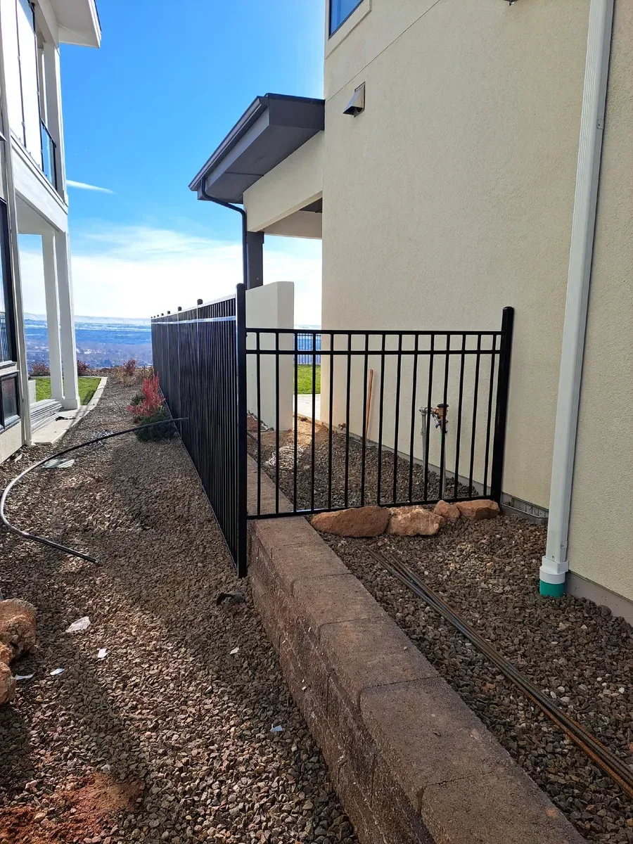 Western three rail capped iron fence and gate on a side yard in the Treasure Valley