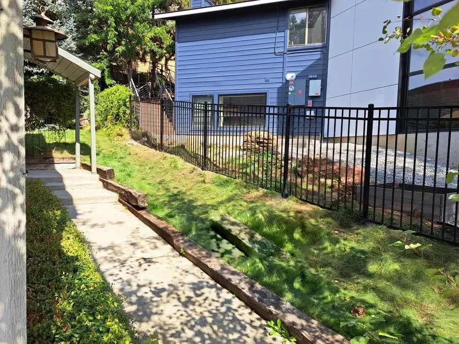 Western three rail rackable iron fence following a slope