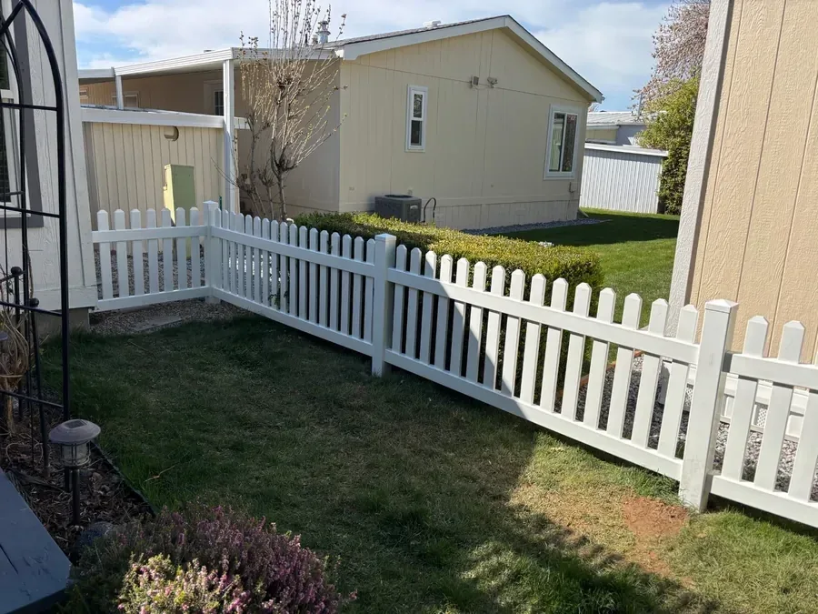 White vinyl picket fence in front of a Caldwell, Idaho home