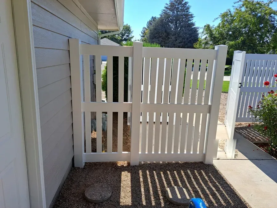 White vinyl picket gate on the side yard of a Boise home
