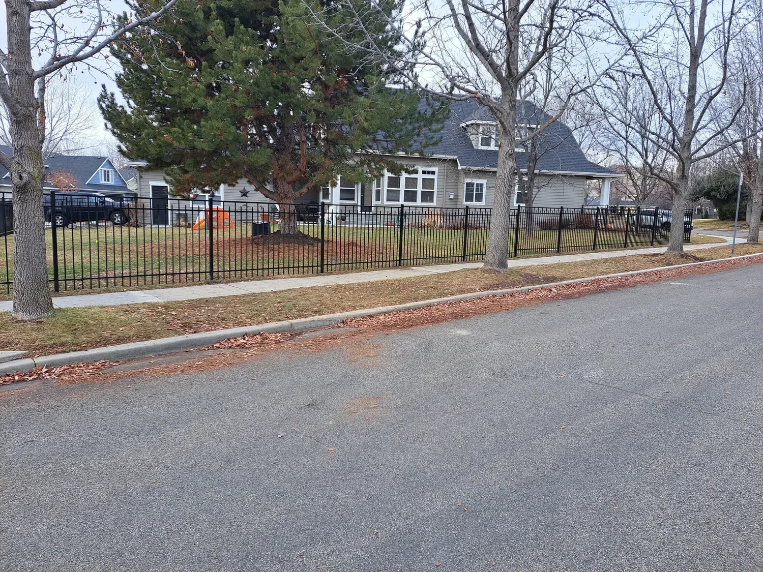 Staggered vista capped wrought iron fence in front of a historic Boise home
