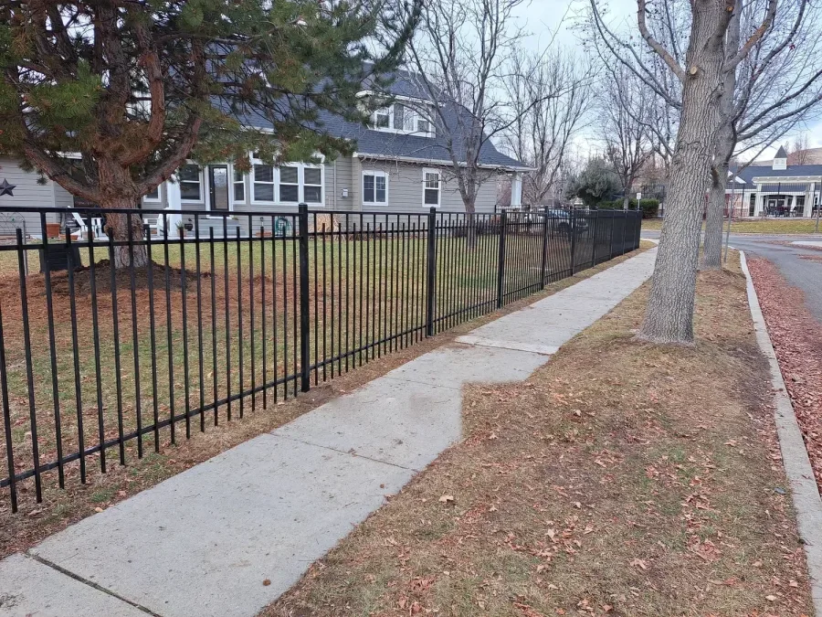 Staggered vista capped wrought iron fence along a tree lined Boise sidewalk